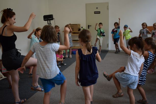 Dzieci ćwiczą podczas warsztatów teatralnych.