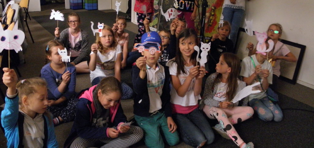 Dzieci prezentują przygotowane przez siebie lalki teatralne.