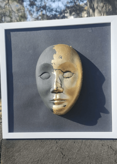 ręcznie wykonana czarno pozłacana maska teatralna w białej ramce