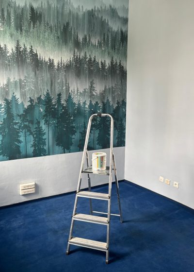 wnętrze pokoju, w tle tapeta z lasem na środku stoi drabina