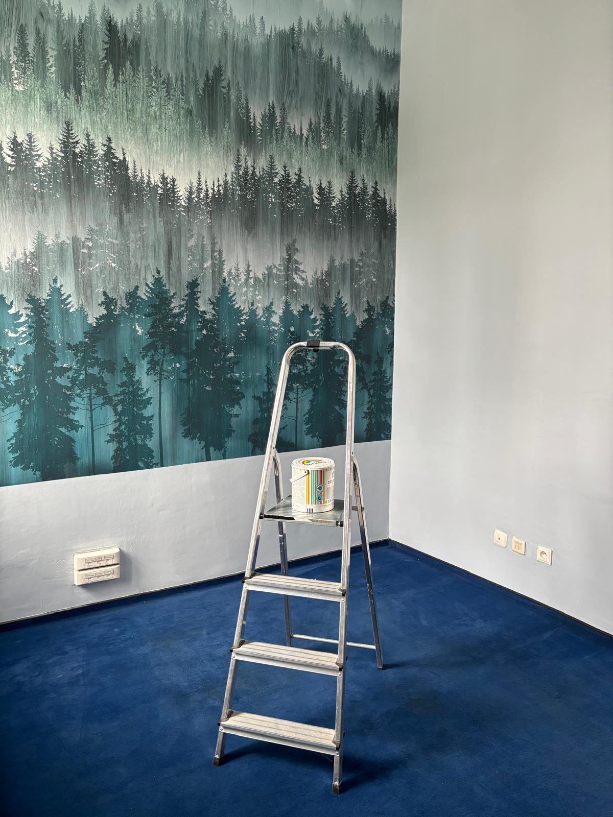 wnętrze pokoju, w tle tapeta z lasem na środku stoi drabina